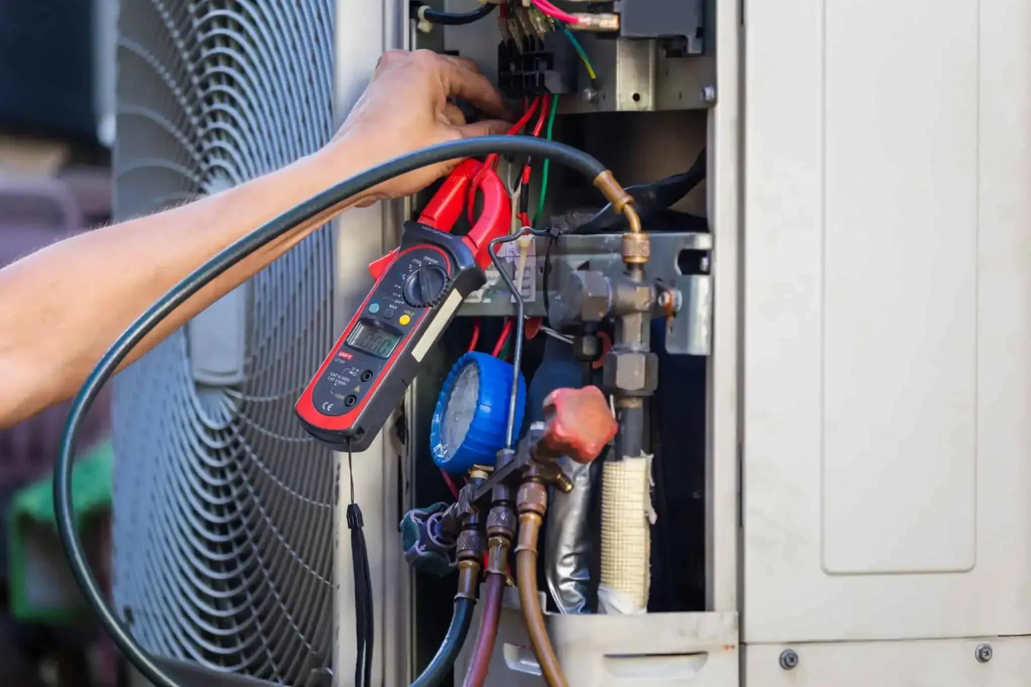 HVAC technician repairing an outdoor air conditioning condenser.