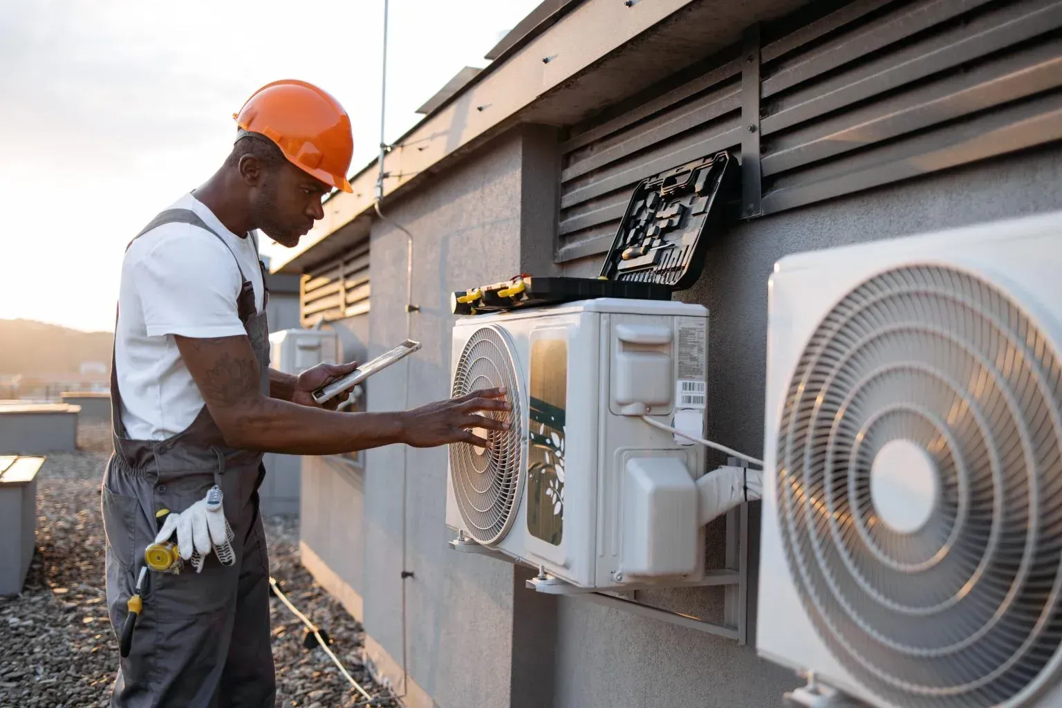 Technicians completing a secure HVAC installation on a rooftop.
