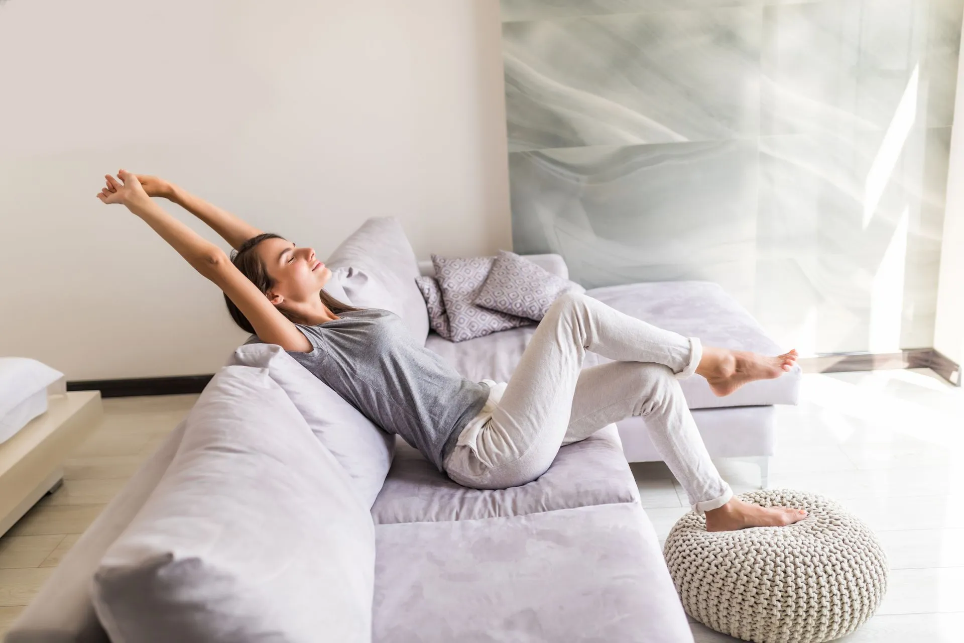 Smiling young woman relaxing on a couch in a cool home.